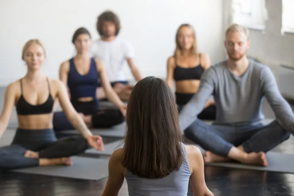 groep-jongeren-en-leraar-zitten-in-padmasana-poseren_1163-4128.jpg